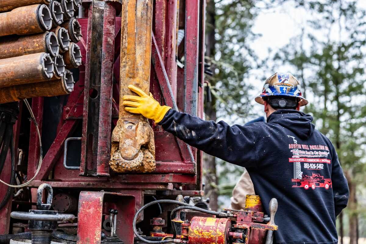 Austin Drilling crew member guiding drill rod on the rig